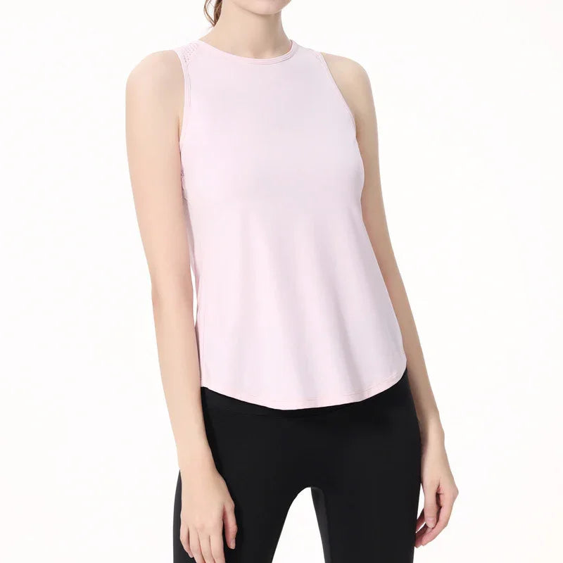 Woman wearing light pink sleeveless athletic tank top and black leggings