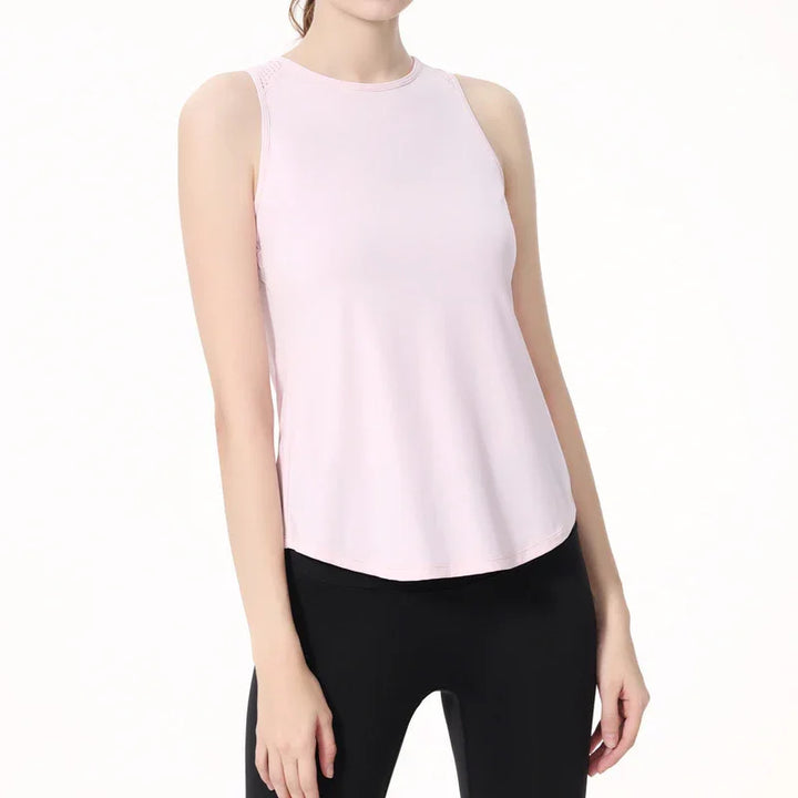 Woman wearing light pink sleeveless athletic tank top and black leggings