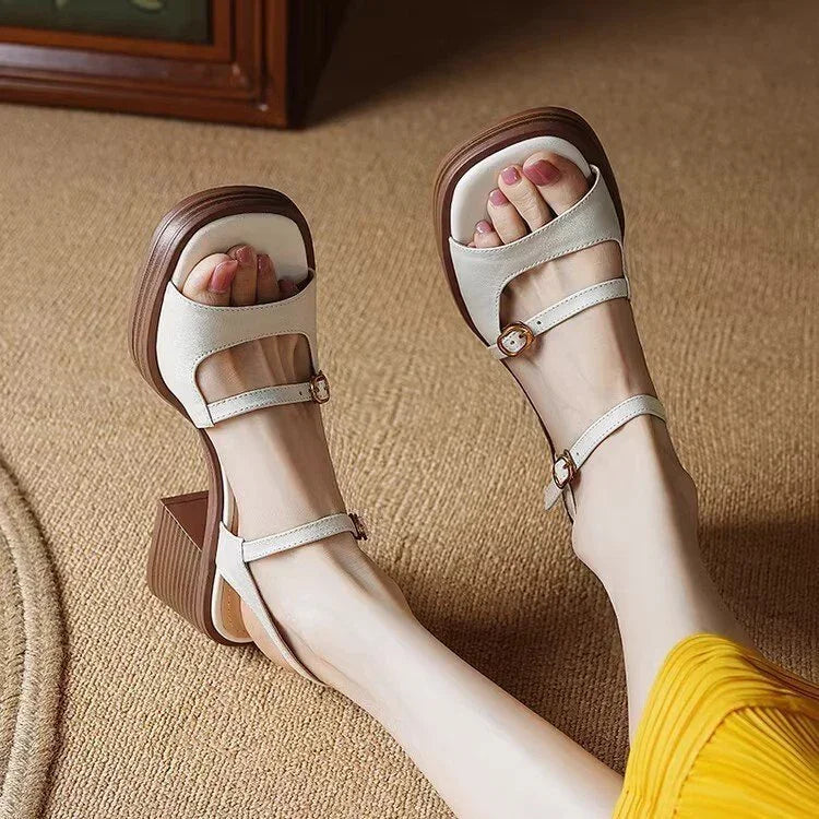 Women wearing white open-toe block heel sandals with ankle straps on beige carpet