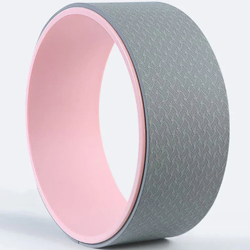 Gray textured yoga wheel with pink inner surface on a light background