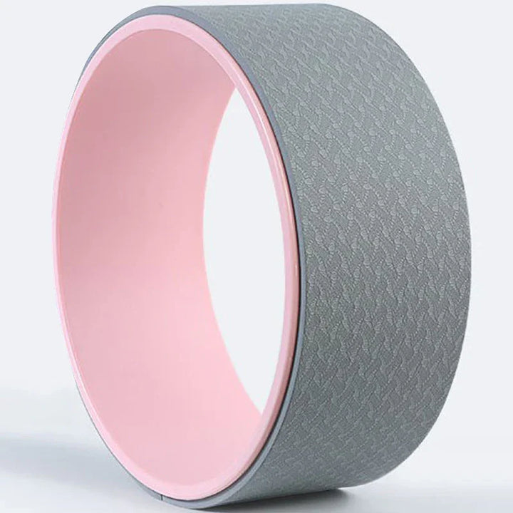 Gray textured yoga wheel with pink inner surface on a light background