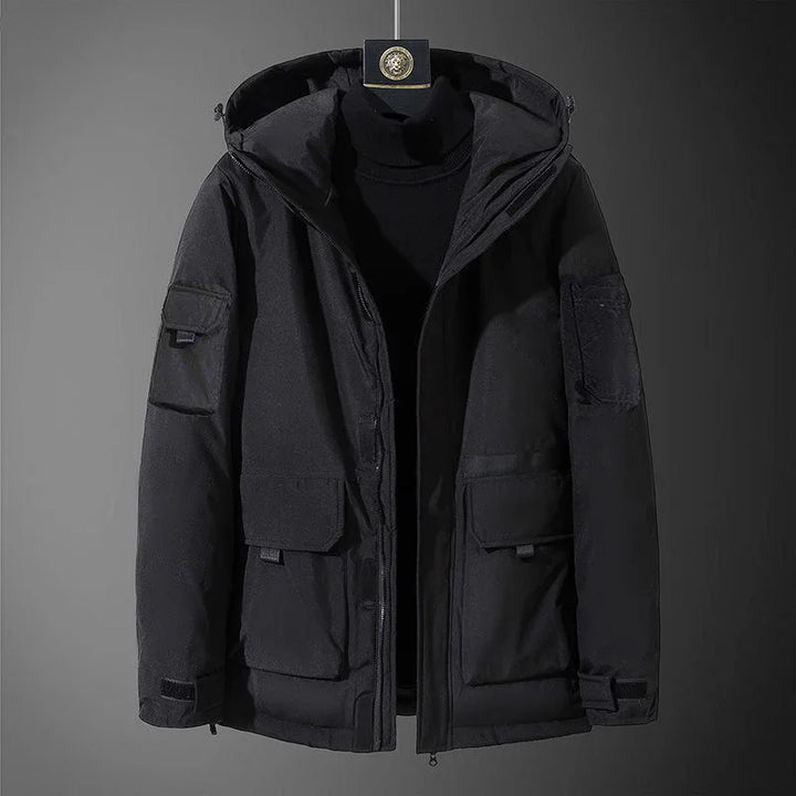 Black hooded winter jacket with multiple flap pockets displayed on black turtleneck sweater