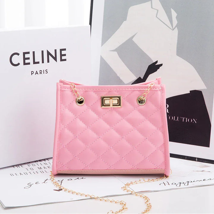 Stylish pink quilted handbag with gold chain and clasp displayed next to CELINE Paris box