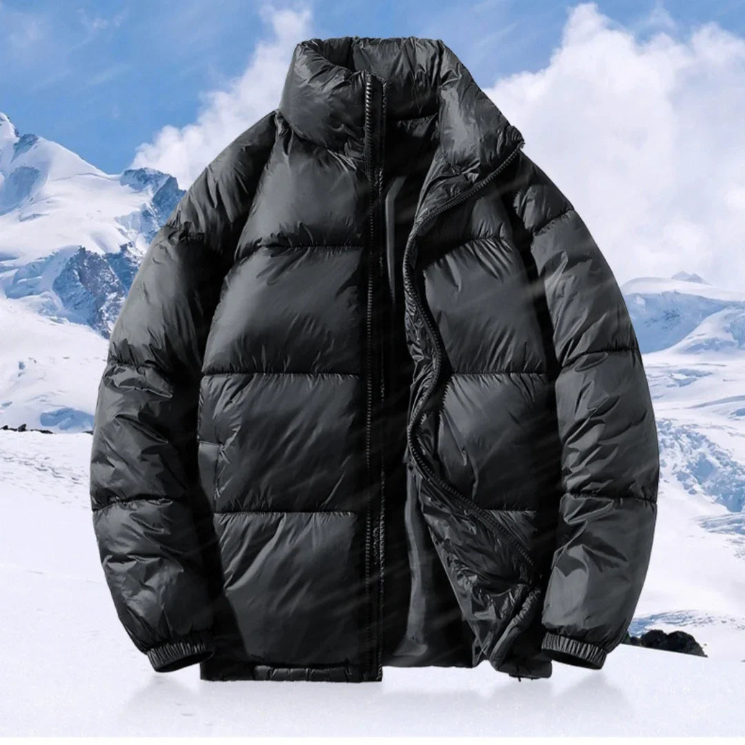 Black puffer jacket with zipper against snowy mountain background, warm winter coat