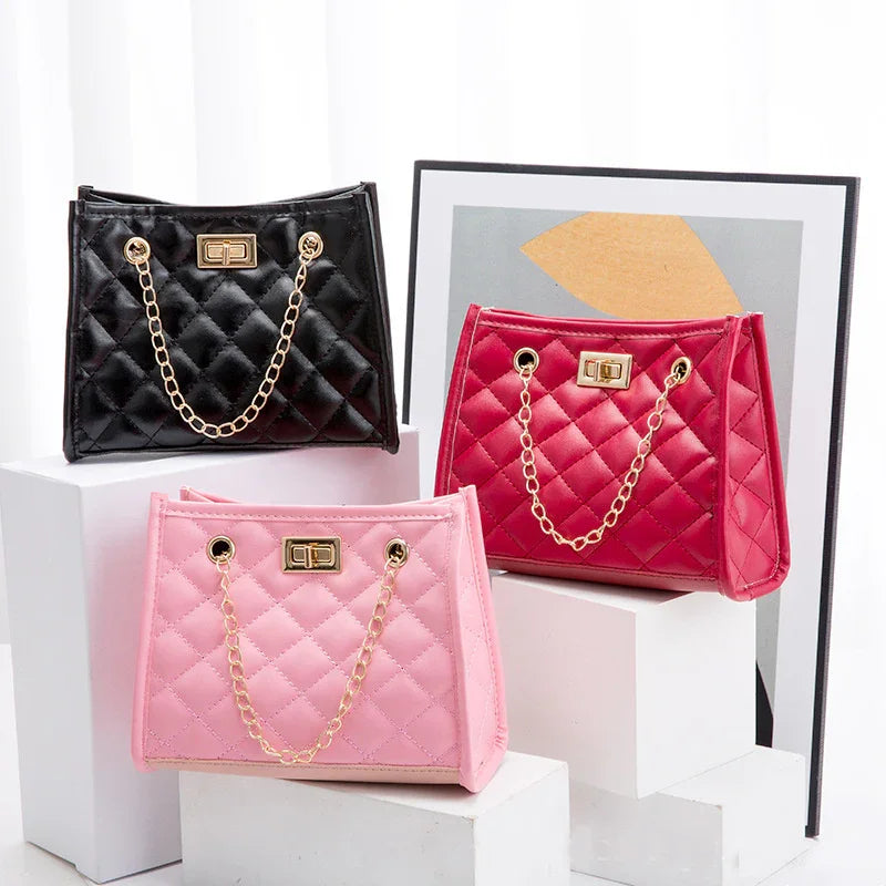 Three quilted handbags in black, red, and pink with gold chain straps displayed on white blocks