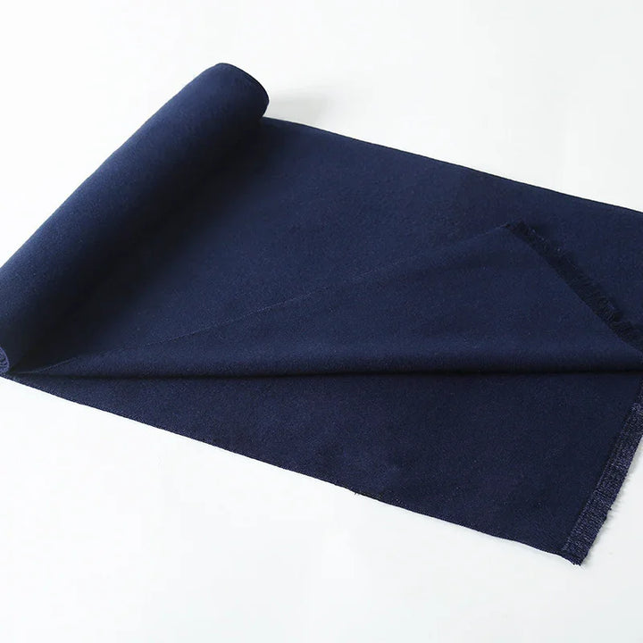 Rolled navy blue fabric textile on white background with a partially unrolled section showing texture