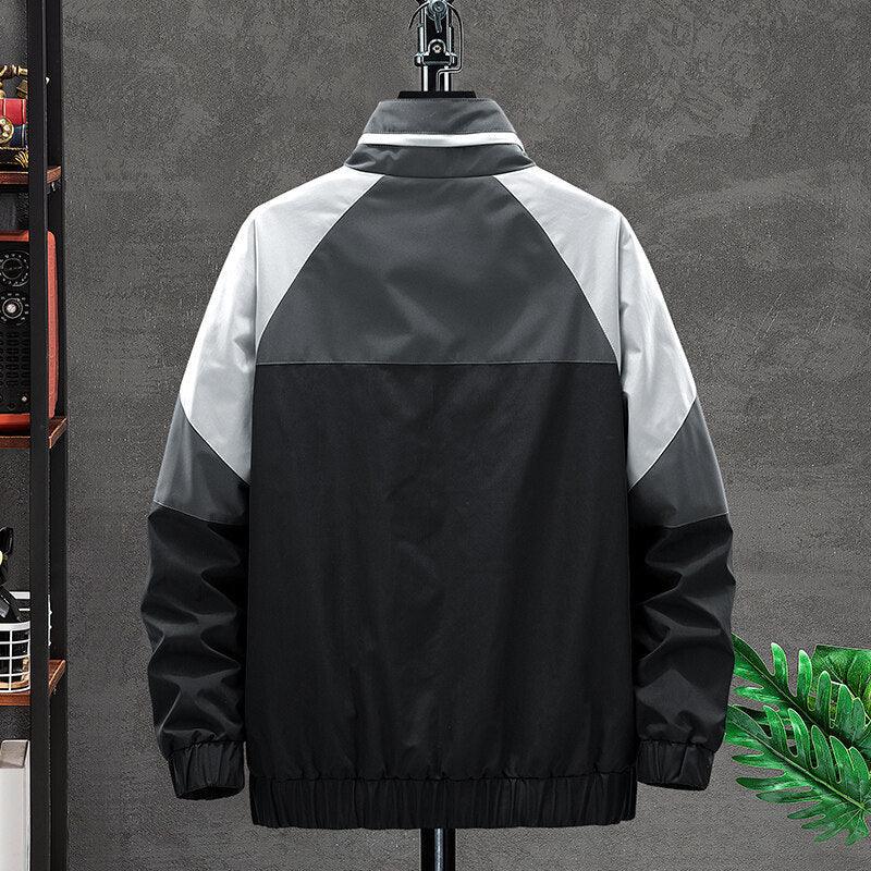 Back view of black and gray color block winter jacket on hanger against gray wall