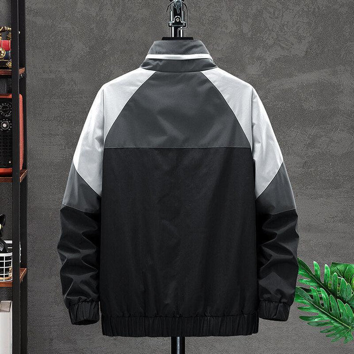 Back view of black and gray color block winter jacket on hanger against gray wall