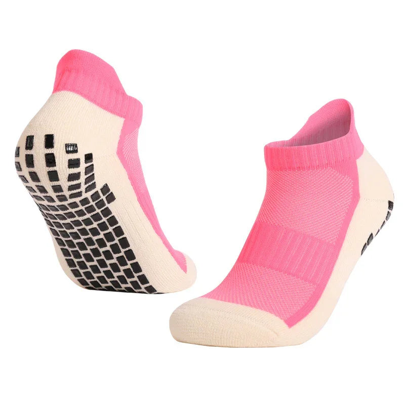 Pink and cream low-cut athletic grip socks with black non-slip soles on white background