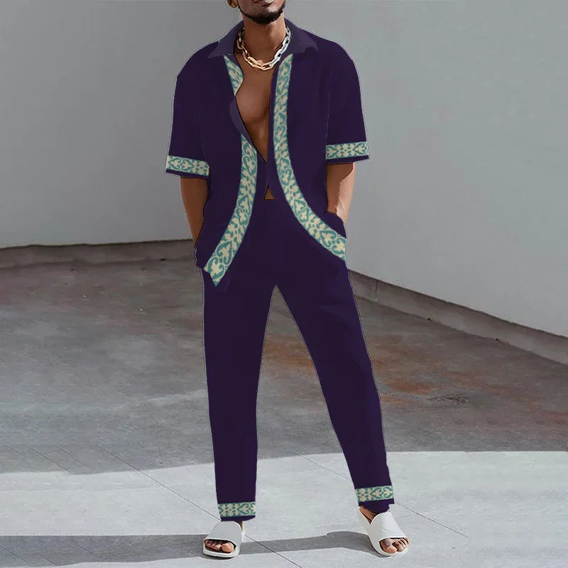 Man wearing dark navy casual set with patterned trim shirt and pants, standing on concrete floor.