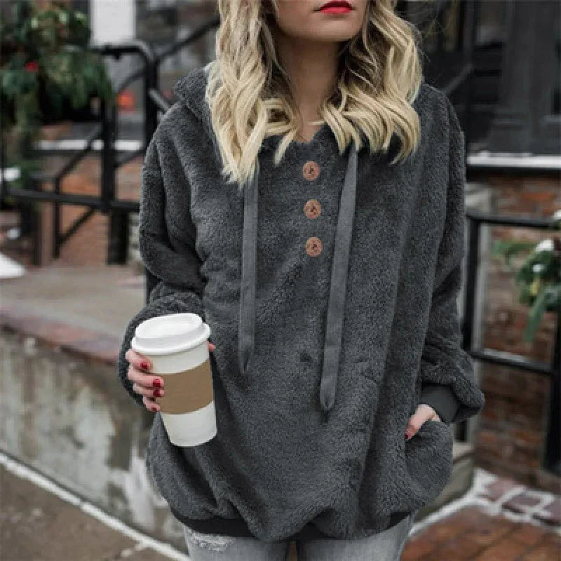 Woman wearing cozy dark gray fleece pullover with buttons holding takeaway coffee cup outdoors