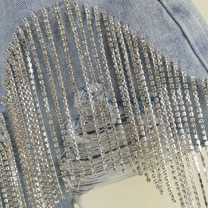 Close-up of light blue distressed denim with vertical silver rhinestone embellishments