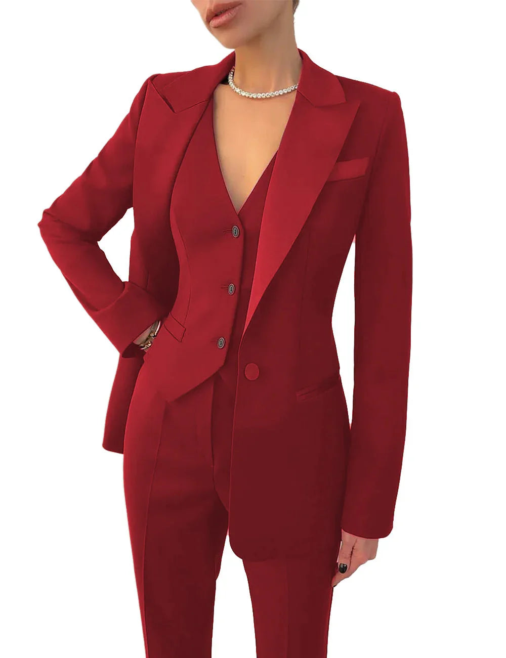 woman wearing a tailored red pantsuit with a blazer and vest, accessorized with a pearl necklace