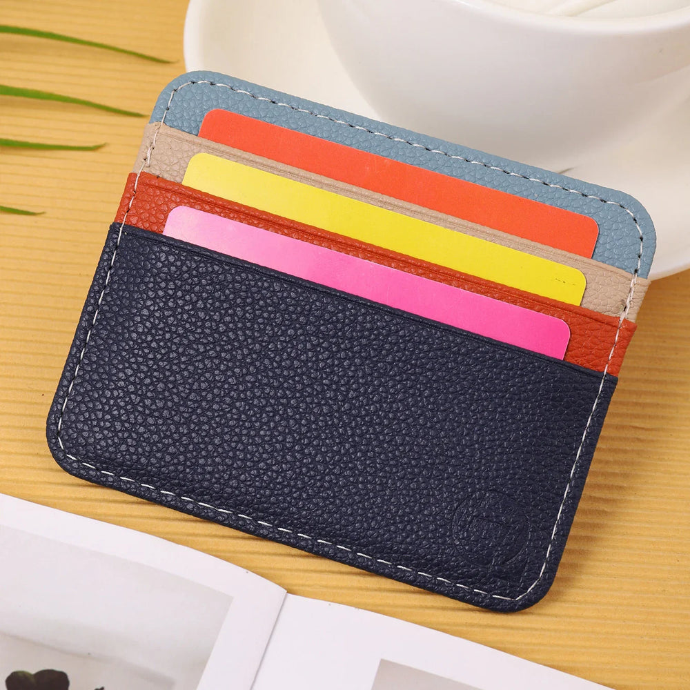 colorful leather card holder with multiple card slots on wooden surface near a white cup and magazine