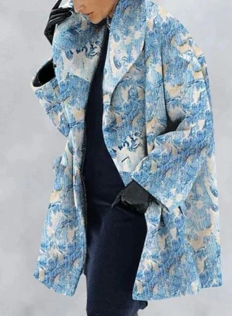 Woman wearing a blue and beige floral patterned oversized coat with black gloves