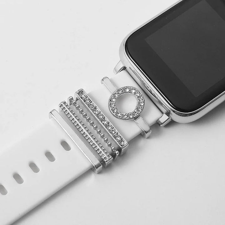 Close-up of a white smartwatch band adorned with silver and rhinestone decorative rings
