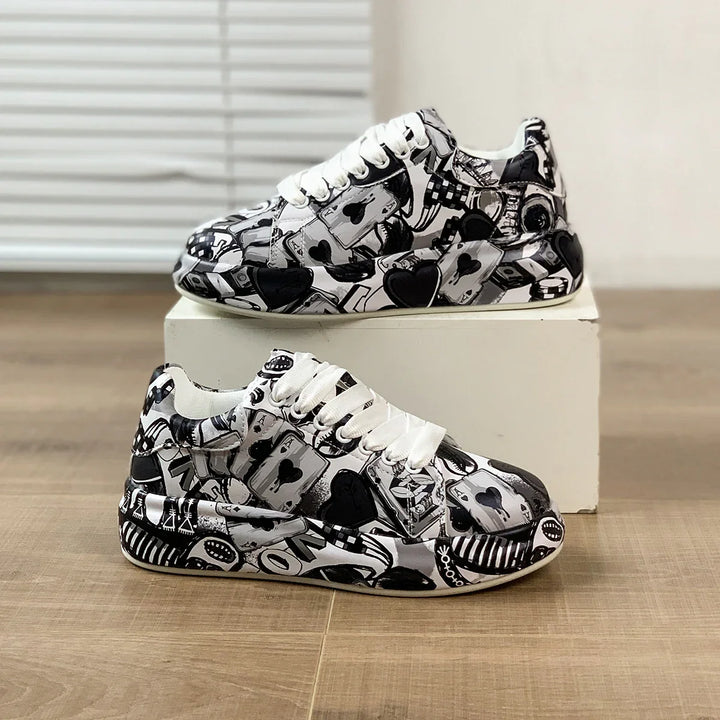 Black and white sneakers with playing card and poker chip pattern on wooden floor and white box