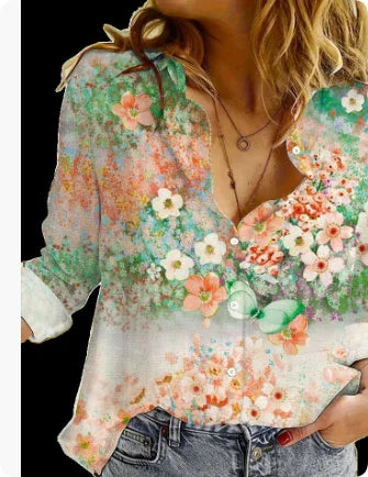 Woman wearing floral print blouse with green, orange, and white flowers paired with blue jeans