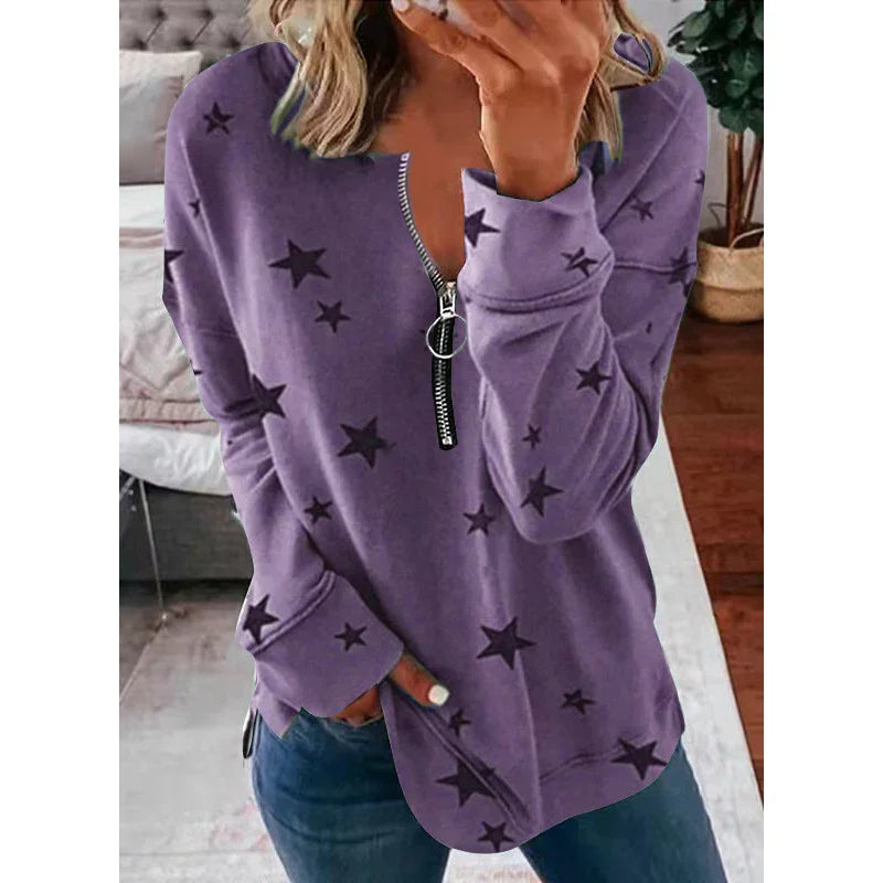 Woman wearing purple star print zip-up sweatshirt with ring pull, casual indoor setting