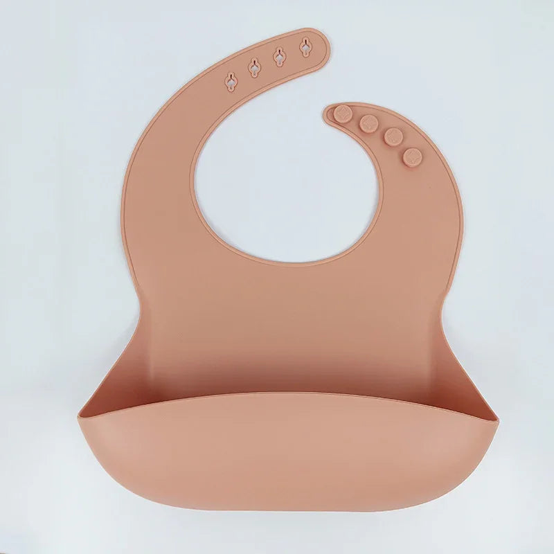 Silicone baby bib in light brown with adjustable button closure and food pocket