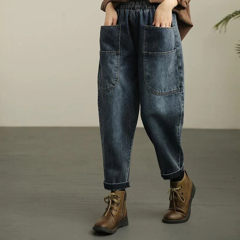 Casual loose-fit dark denim pants with large front pockets paired with brown lace-up ankle boots