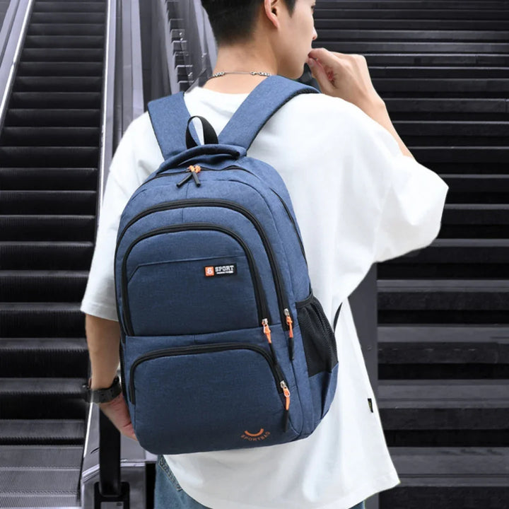 Person wearing a blue sport backpack with multiple compartments near escalators