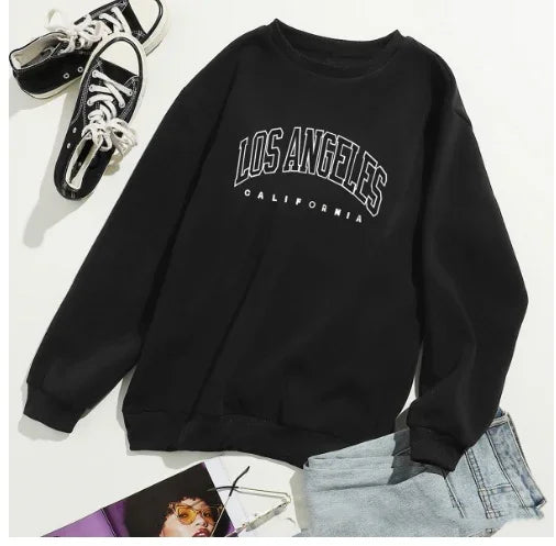 Black sweatshirt with 'Los Angeles California' text, paired with black sneakers and light blue jeans