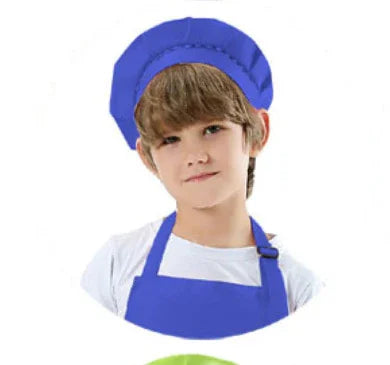 Young boy wearing a blue chef hat and apron on white background