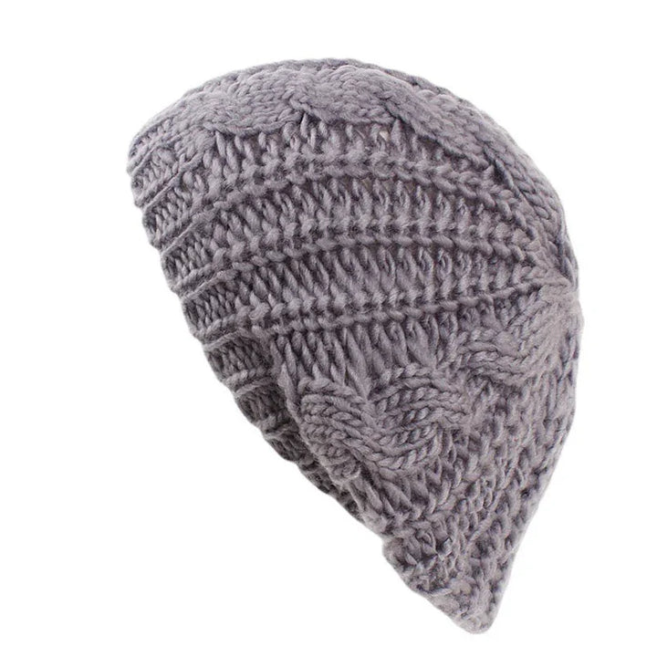 Gray knitted wool beanie hat with cable and ribbed stitch patterns isolated on white background