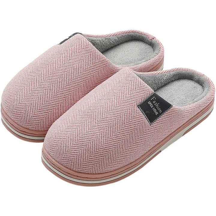 Pair of pink herringbone pattern indoor slippers with soft grey lining and cushioned soles