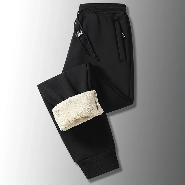 Black fleece-lined jogger pants with drawstring waist and side pockets on gradient background