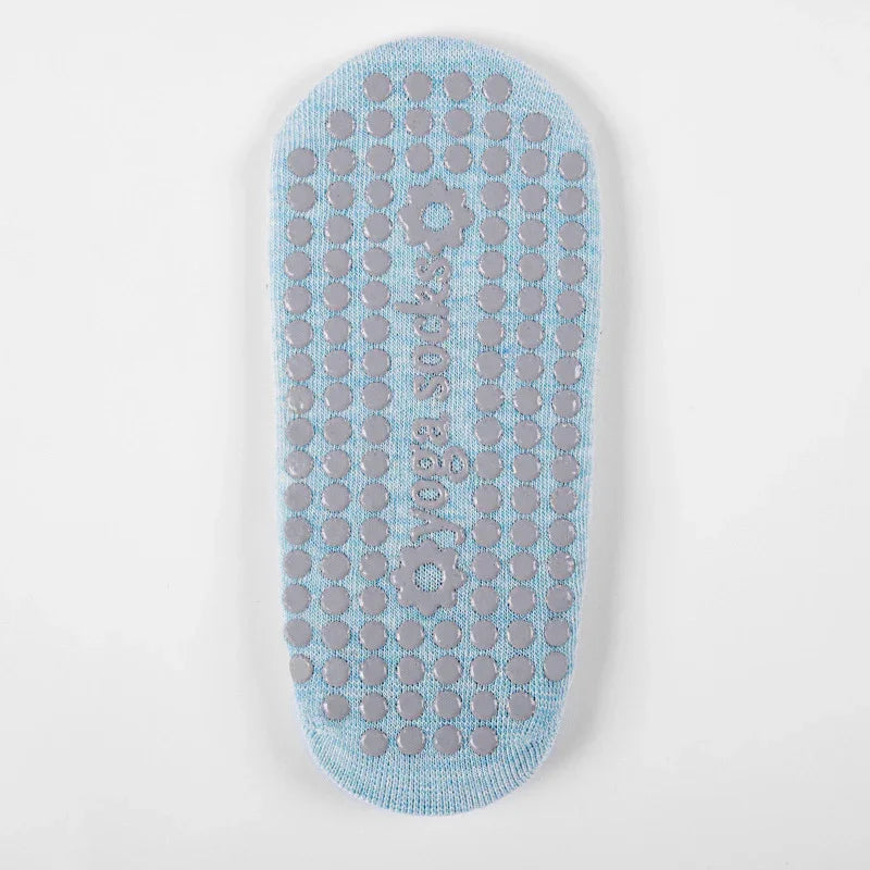Light blue yoga socks with non-slip gray grip dots and floral grip patterns on sole
