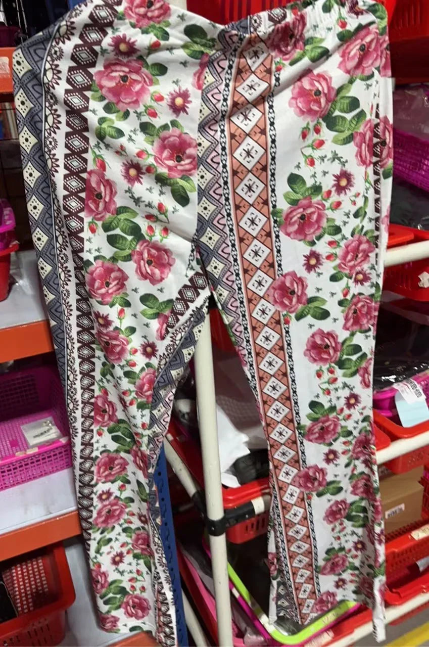 White pants with pink floral and geometric border patterns hanging in storage shelves