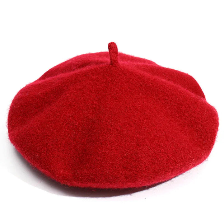 Classic red wool beret hat with top stem on white background