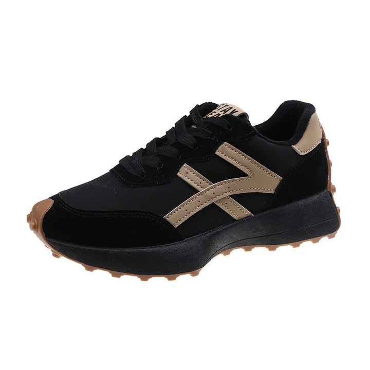 Black and tan athletic sneaker with textured sole, lace-up design, and side stripe detail