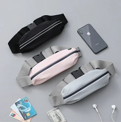 Three zipper waist bags in black, pink, and gray with phone, cards, cash, and earphones on gray background