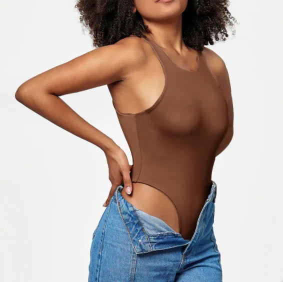 woman wearing brown sleeveless bodysuit and unbuttoned blue denim jeans on white background