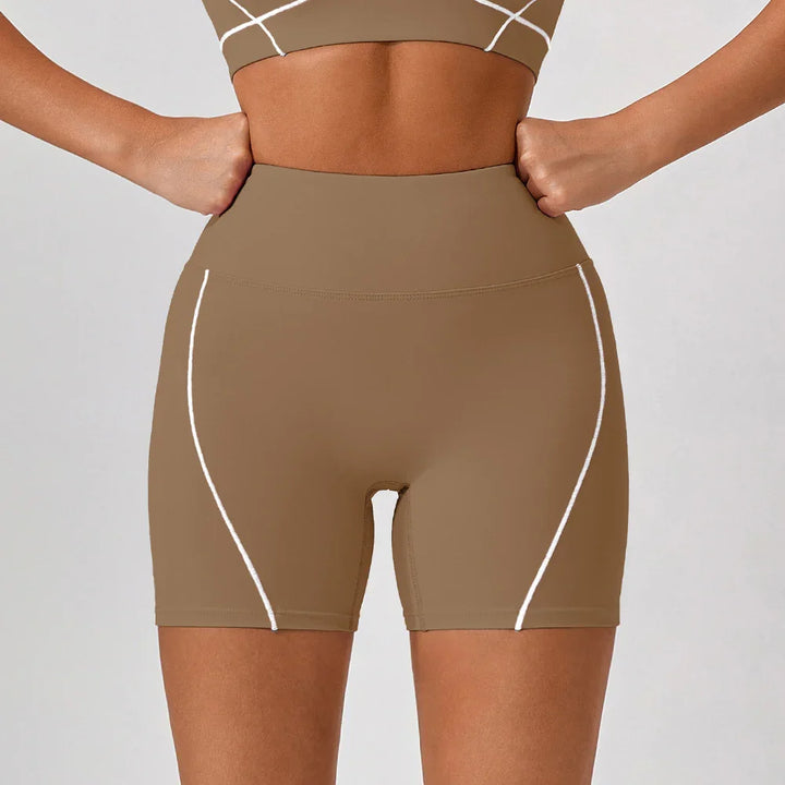 Close-up of a woman wearing brown high-waisted workout shorts with white seam accents