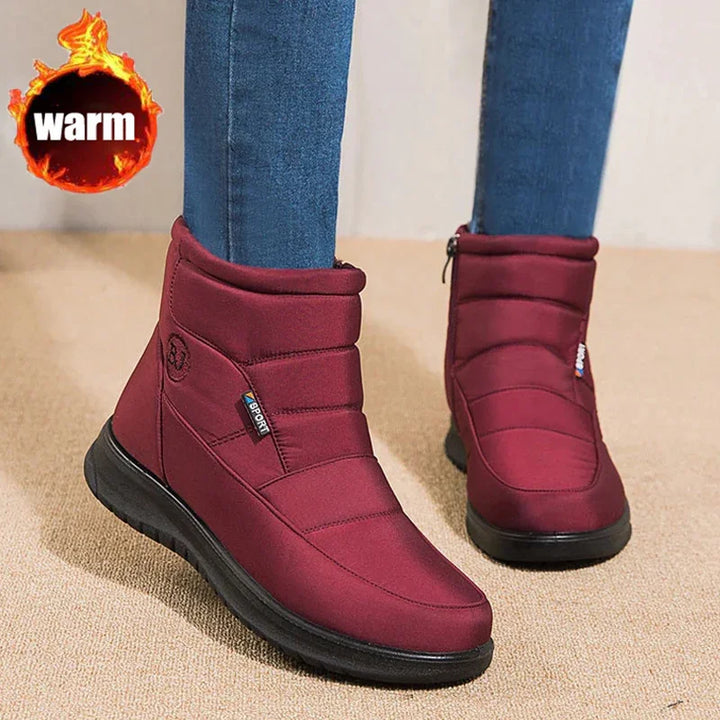 Women’s warm burgundy winter boots with black soles worn with blue jeans
