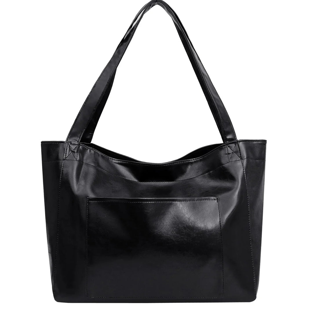 Black leather tote bag with front pocket and shoulder straps on white background