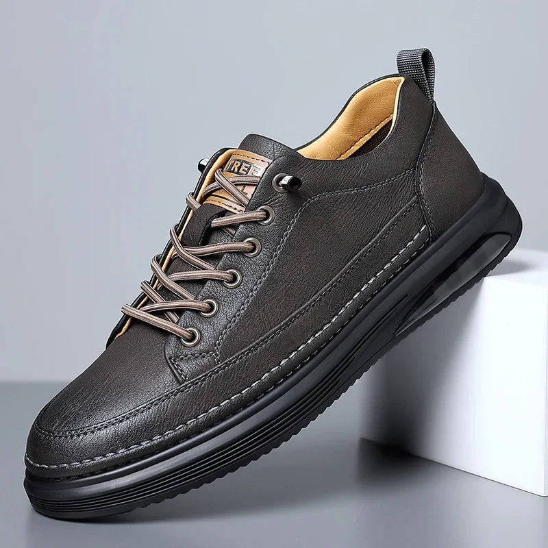 Black leather casual sneaker with brown laces and cushioned sole on gray background