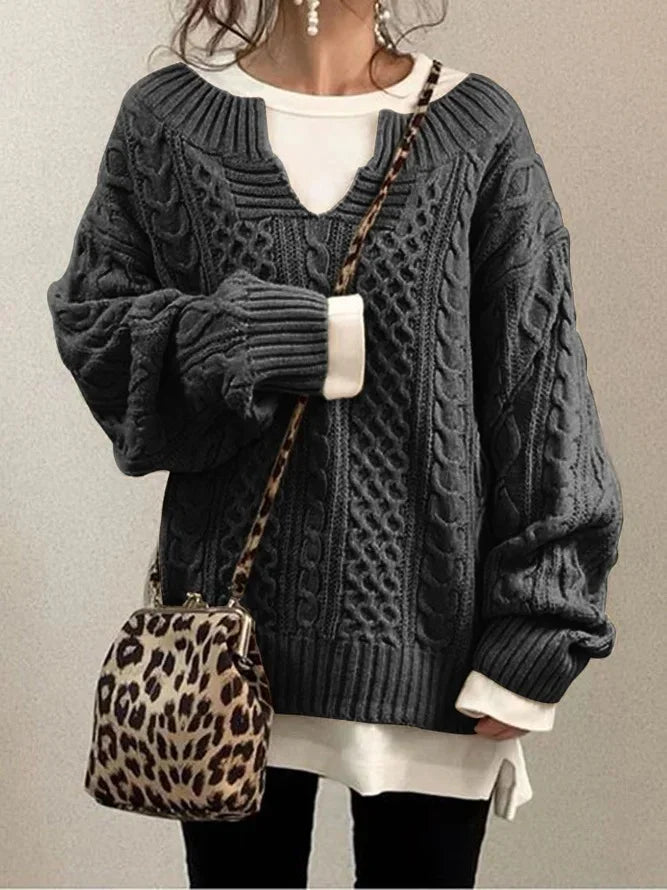 Woman wearing dark gray cable knit sweater layered over white shirt with leopard print crossbody bag