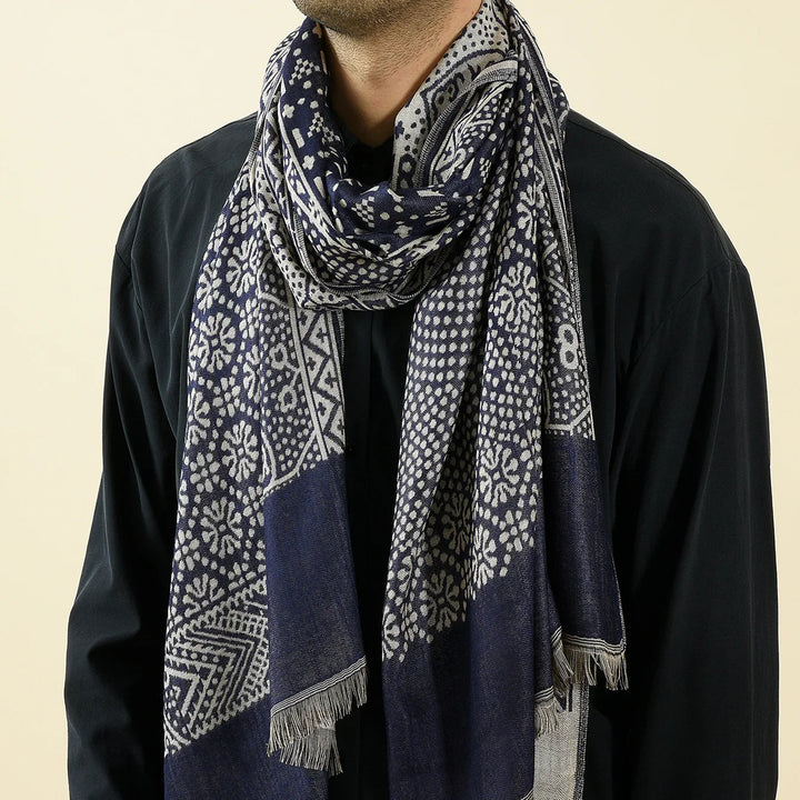 Close-up of man wearing navy blue patterned scarf with white floral and geometric designs over black shirt