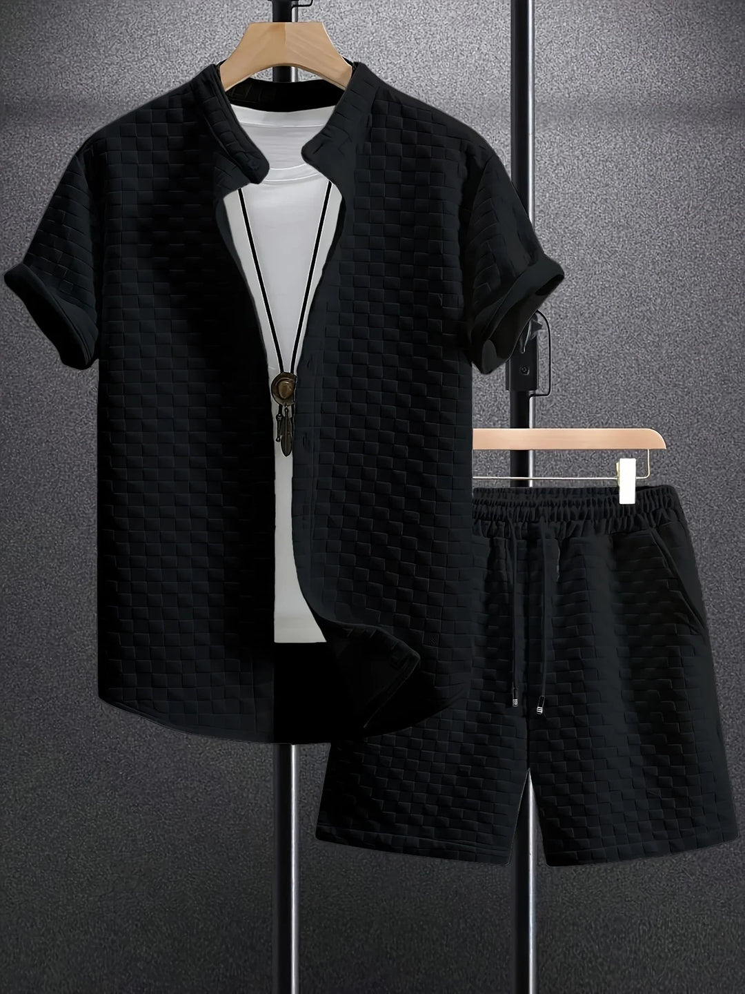 Black short-sleeve shirt and matching shorts with textured square pattern on hangers