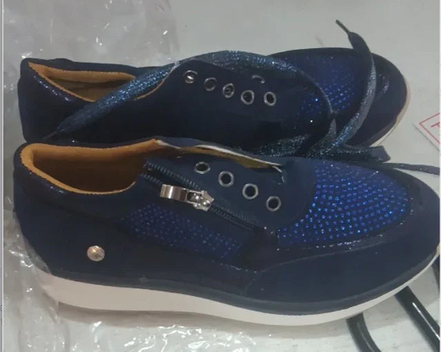 Pair of navy blue casual sneakers with zipper and lace details on white soles