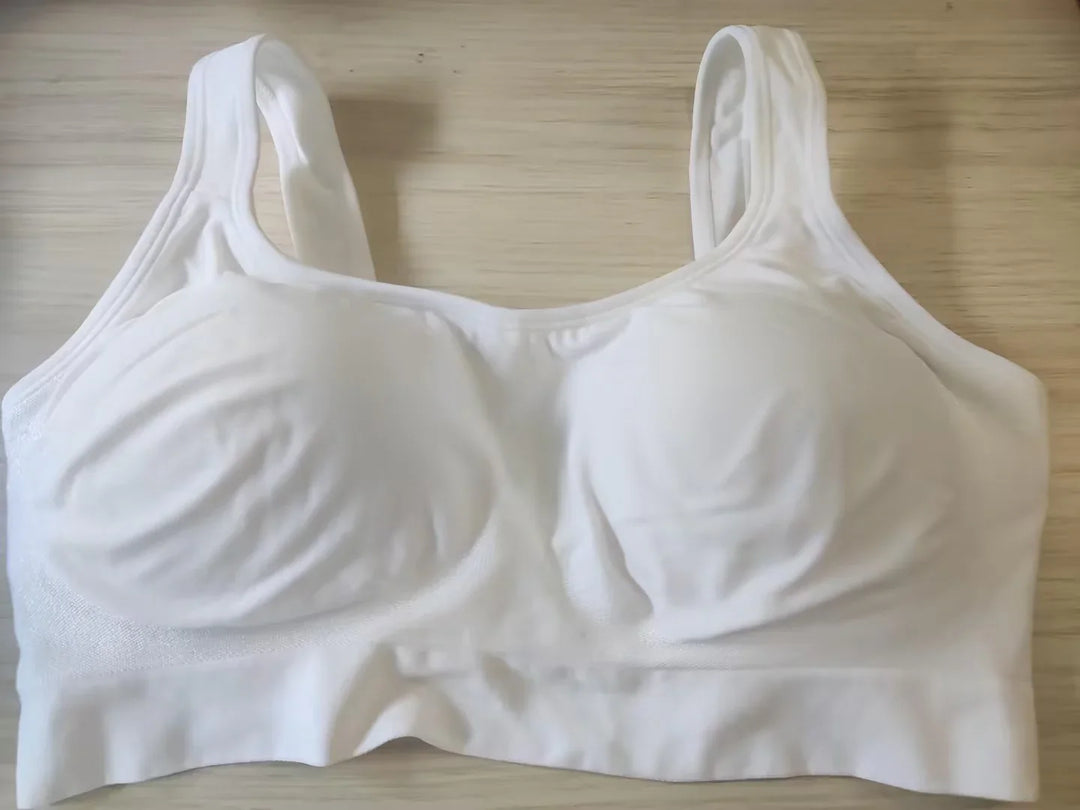 White wireless padded bra with wide straps laid flat on wooden surface