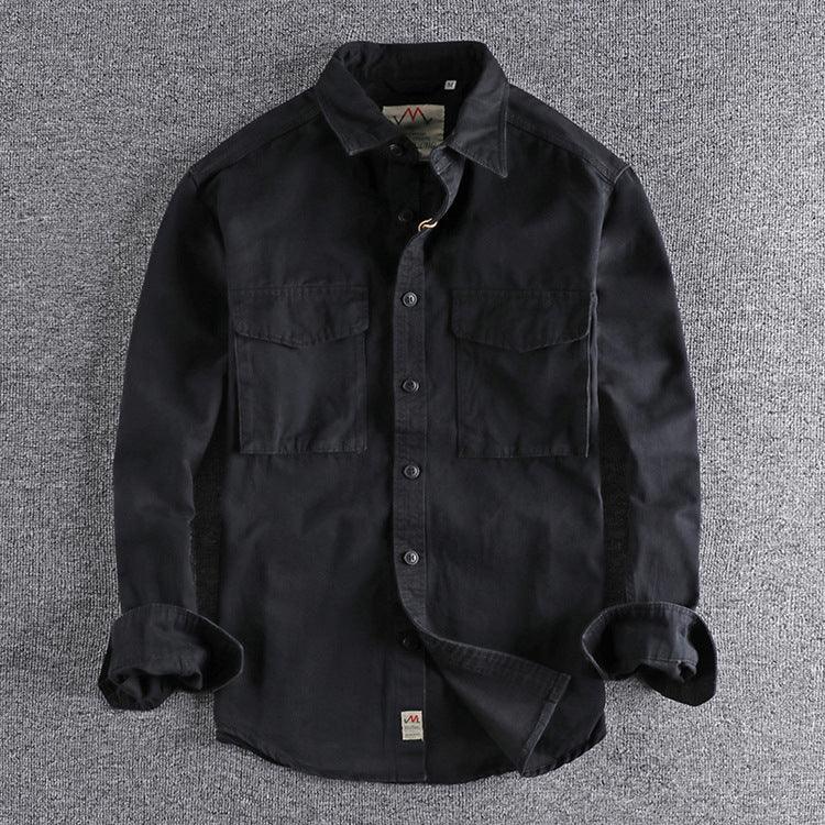Black long-sleeve button-up shirt with chest pockets on grey fabric background