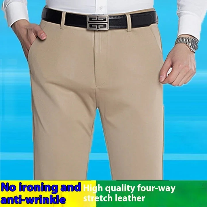 Man wearing beige anti-wrinkle pants with black belt and white shirt against blue background