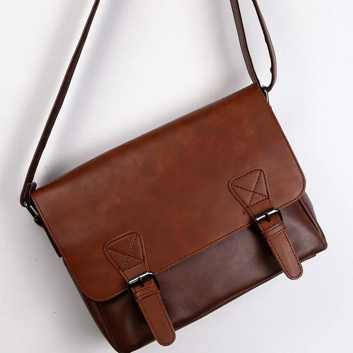 Two-tone brown leather crossbody bag with adjustable strap and buckle closures