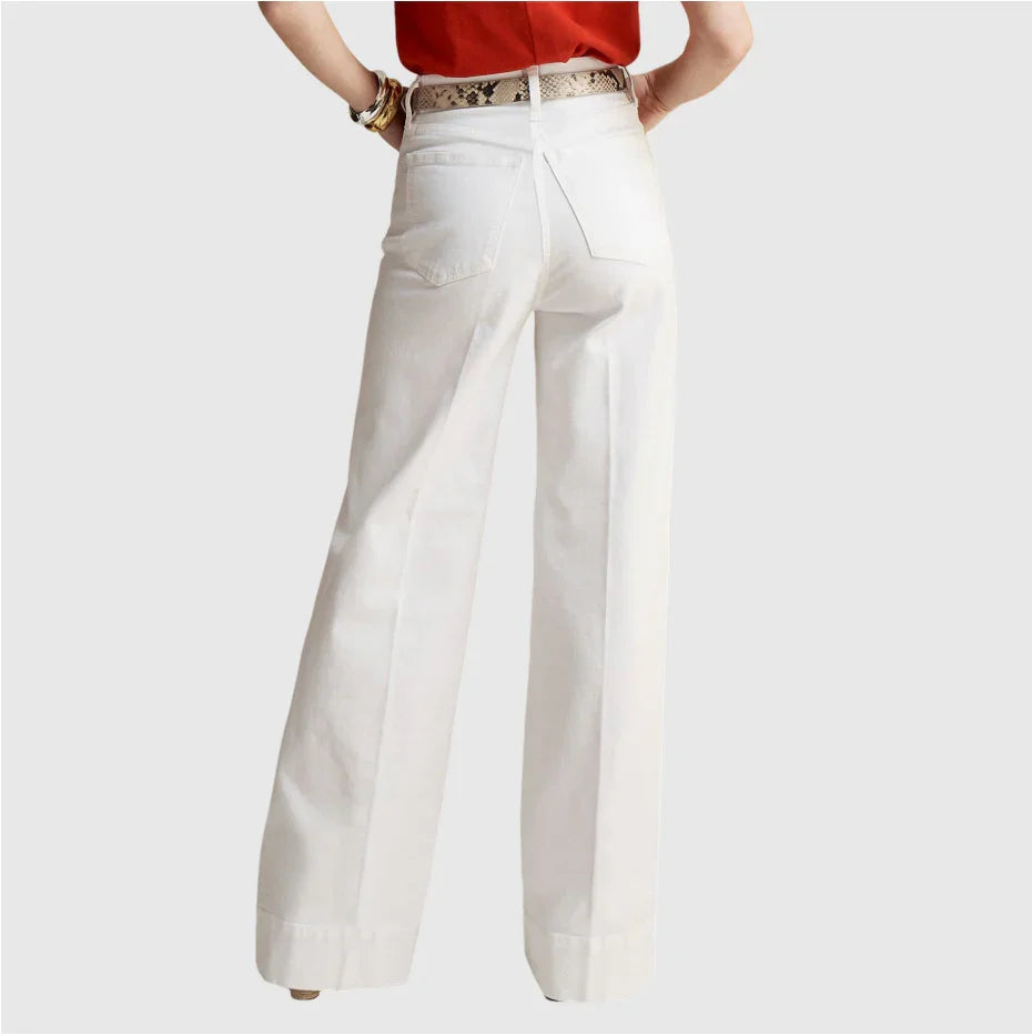 Back view of woman wearing white wide-leg pants with a snakeskin belt and red top